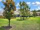 Backyard with trees, green grass, and a screened-in porch at 11522 Cambium Crown Dr, Riverview, FL 33569