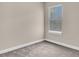Empty bedroom corner with neutral walls, plush carpet, and a single window at 11522 Cambium Crown Dr, Riverview, FL 33569