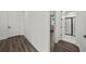 Hallway with modern flooring that leads to a bathroom with glass shower and marble tile at 3778 Maxwell Park Dr, Sun City Center, FL 33573