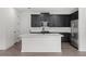 Modern kitchen with dark cabinets, stainless steel appliances, white subway tile, and a center island at 3778 Maxwell Park Dr, Sun City Center, FL 33573