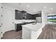 Bright kitchen featuring dark cabinetry, white countertops, and a large center island with a sink at 3778 Maxwell Park Dr, Sun City Center, FL 33573