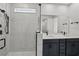Bathroom with marble tile, a walk-in shower, and double vanity at 3778 Maxwell Park Dr, Sun City Center, FL 33573