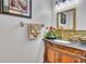 Elegant bathroom with dark vanity, decorative tile, and gold fixtures at 12711 Royal George Ave, Odessa, FL 33556