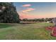 Landscaped backyard with pond and scenic sunset view at 12711 Royal George Ave, Odessa, FL 33556