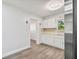Modern kitchen with white cabinets, stainless steel appliances, and wood-look floors at 5061 Jasmine Cir, St Petersburg, FL 33714