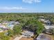 Aerial view of a single-Gathering home with a large tree in the backyard and surrounding neighborhood at 5061 Jasmine Cir, St Petersburg, FL 33714