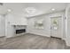 Bright living room featuring a modern fireplace and grey wood-look floors at 5061 Jasmine Cir, St Petersburg, FL 33714