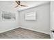 Bright bedroom with wood-look flooring, ceiling fan, and window blinds at 5061 Jasmine Cir, St Petersburg, FL 33714