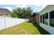 Spacious backyard with grassy area, white vinyl fence, and AC unit at 1702 Blind Pond Ave, Lutz, FL 33549