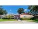 Front view of a brick ranch home with landscaping and a covered entry at 1702 Blind Pond Ave, Lutz, FL 33549
