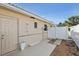 Backyard area with concrete patio and gravel landscaping alongside the house, leading to a gated fence at 186 45Th Ave, St Pete Beach, FL 33706