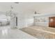 Bright and open living room with tile flooring, fan, and open views of adjacent kitchen and front door at 186 45Th Ave, St Pete Beach, FL 33706