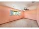 Empty room with carpet floor, ceiling fan, and window view of the backyard at 2115 Seagull Dr, Clearwater, FL 33764