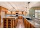 Bright kitchen featuring granite countertops, wooden cabinetry, modern appliances, and tile backsplash at 2115 Seagull Dr, Clearwater, FL 33764