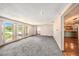 Bright, open living room with large windows, plush carpeting, and hardwood floors leading to other spaces at 2115 Seagull Dr, Clearwater, FL 33764