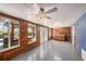 Bright sunroom with wood paneled walls, ceiling fan, wet bar, and views of the pool and backyard entertainment area at 2115 Seagull Dr, Clearwater, FL 33764