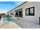 Beautiful backyard showcasing a pool and spa with gray tiled patio and outdoor living space at 6540 Simone Shores Cir, Apollo Beach, FL 33572