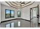 Bedroom featuring windows with black trim, tray ceiling and gray marble floors at 6540 Simone Shores Cir, Apollo Beach, FL 33572