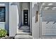 The home's front door is accessed by stone steps, and is framed by a modern light fixture at 6540 Simone Shores Cir, Apollo Beach, FL 33572