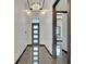 Stunning home foyer with a modern chandelier, shiny stone floors, and trim lighting at 6540 Simone Shores Cir, Apollo Beach, FL 33572