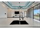 Modern Kitchen island and sink and living room in the background at 6540 Simone Shores Cir, Apollo Beach, FL 33572