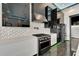Modern kitchen features a black gas range, mosaic backsplash and stainless appliances at 6540 Simone Shores Cir, Apollo Beach, FL 33572