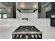 Close up of a gas range and backsplash with stainless steel range hood at 6540 Simone Shores Cir, Apollo Beach, FL 33572