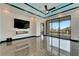 Spacious living room featuring stone floors, a modern fireplace, and large sliding glass doors at 6540 Simone Shores Cir, Apollo Beach, FL 33572