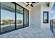 This outdoor patio boasts sleek, black-framed sliding glass doors and patterned brick flooring at 6540 Simone Shores Cir, Apollo Beach, FL 33572