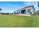 Back exterior view of a charming house with a grassy lawn at 6540 Simone Shores Cir, Apollo Beach, FL 33572
