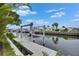 Waterfront property with a large boat lift on a private dock surrounded by lush trees and waterfront homes at 6542 Simone Shores Cir, Apollo Beach, FL 33572