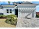 Close-up view of a charming home with a two-car garage, paved driveway, and well-maintained landscaping at 6542 Simone Shores Cir, Apollo Beach, FL 33572