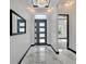 Elegant foyer with marble floors, modern lighting, a black trimmed doorway, and a contemporary front door at 6542 Simone Shores Cir, Apollo Beach, FL 33572