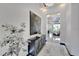 Bright hallway featuring a black cabinet and leading to a living room with chandeliers and luxury furniture at 6542 Simone Shores Cir, Apollo Beach, FL 33572