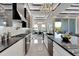 Modern kitchen with stainless steel appliances, white cabinets, dark countertops, and view to an outdoor dining area at 6542 Simone Shores Cir, Apollo Beach, FL 33572