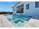 Gorgeous pool and spa with a safety fence is surrounded by a light blue house under a bright blue sky at 6542 Simone Shores Cir, Apollo Beach, FL 33572