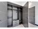 Modern walk-in closet with gray wood shelving and drawers at 6542 Simone Shores Cir, Apollo Beach, FL 33572