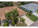 Aerial view of single-story house with brown roof and lush landscaping at 912 Oxford Park Dr, Sun City Center, FL 33573