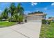 Single-story house with palm trees, lush lawn, and a two-car garage at 912 Oxford Park Dr, Sun City Center, FL 33573