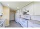 Modern kitchen with white cabinets, stainless steel appliances, and light grey countertops at 912 Oxford Park Dr, Sun City Center, FL 33573