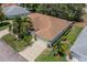 Aerial view of single-story house with brown roof and lush landscaping at 912 Oxford Park Dr, Sun City Center, FL 33573