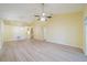 Large living room with vaulted ceilings, ceiling fan, and laminate flooring at 912 Oxford Park Dr, Sun City Center, FL 33573