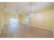 Spacious living room featuring light walls, wood-look flooring, and multiple light fixtures at 912 Oxford Park Dr, Sun City Center, FL 33573