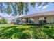 Back of house showing a large yard and sunroom at 912 Oxford Park Dr, Sun City Center, FL 33573