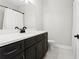 Well-lit bathroom featuring a dark vanity, white countertop, and a shower with a white shower curtain at 4606 W Fig St # 4, Tampa, FL 33609