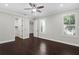 This bedroom features hardwood floors, neutral walls, ceiling fan, a window, and a walk-in closet at 4606 W Fig St # 4, Tampa, FL 33609