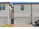 Exterior view of multi-unit townhouse with individual garages and paved driveways at 4606 W Fig St # 4, Tampa, FL 33609