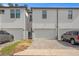 Exterior view of multi-unit townhouse with individual garages and paved driveways at 4606 W Fig St # 4, Tampa, FL 33609