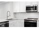 Modern kitchen features stainless steel appliances, white cabinets, and stylish backsplash at 4606 W Fig St # 4, Tampa, FL 33609