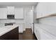Bright kitchen features white cabinets, stainless steel appliances, a dark island, and beautiful wood floors at 4606 W Fig St # 4, Tampa, FL 33609